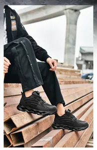 Detail of all-black safety work shoe featuring a twist knob lacing system and wave sole