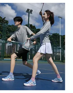 Nahaufnahme der blauen Badmintonschuhe mit Drehverschluss und grauer Sportkleidung