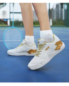 Détail de chaussures de badminton respirantes avec touches dorées sur le terrain