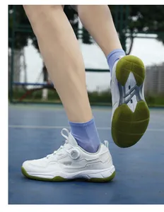 Detail of white sports shoes with swivel dial laces and green anti-slip honeycomb sole