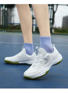 Detail of white breathable mesh sports shoe with green sole and rotary lacing system