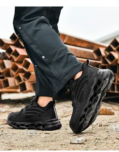 Close-up of black safety toe shoes with durable wave soles in an outdoor work scene