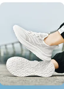 Close-up of breathable mesh fabric and thick anti-slip sole on white summer running shoe