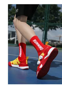 Detail von rot-gelben Sportschuhen mit Drehverschluss-Schnürsystem auf blauem Spielfeld