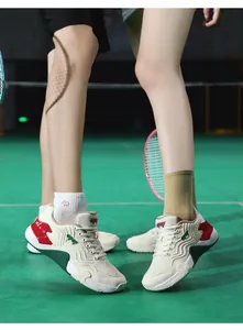 Détail de chaussures de badminton respirantes avec semelles ondulées sur terrain vert