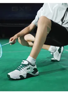 Gros plan de chaussure de badminton respirante avec détails verts sur terrain pro