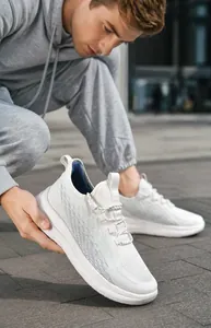 Baskets en maille flyknit blanche respirante avec semelle épaisse sur chemin de pierre