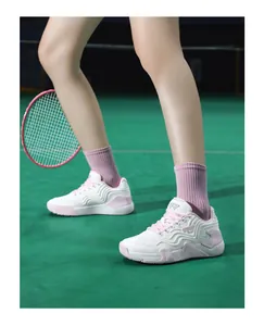 Détail de la chaussure de badminton blanc et rose avec mesh respirant sur terrain vert