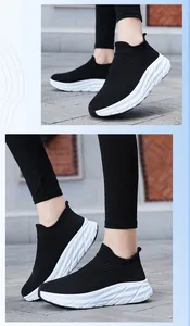 Baskets chaussettes en maille noire respirante avec semelles blanches sur pavés