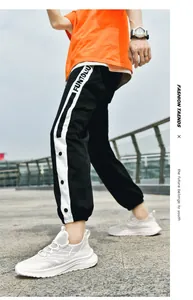 Outdoor street style look with bright orange T-shirt and black side-striped joggers
