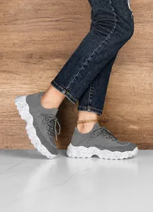 Close-up of gray breathable knitted sneakers with platform speckled soles for comfort