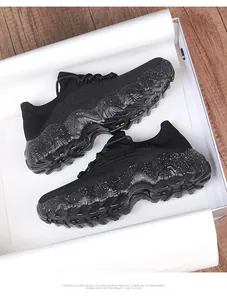 Detail of breathable knit upper and thick speckled sole on black walking shoes