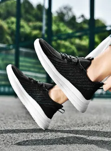 Vue latérale de baskets de course en maille respirante noire avec semelle MD blanche