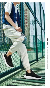 Outdoor shot of breathable black mesh sneakers with thick white soles on a sports court