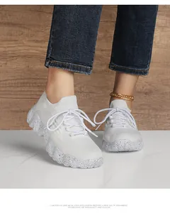 Detail of white breathable mesh sneaker with speckled sole and knit texture on feet