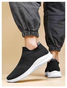 Detail of black knitted slip-on sneakers with lightweight white cushioning soles