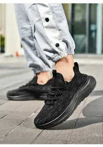 Macro view of breathable black knit mesh and thick anti-slip sole on men's running shoe