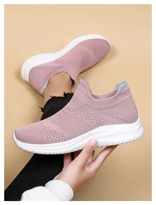 Close-up detail of pink knit mesh walking shoes with thick white rubber sole
