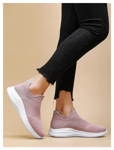 Detail of pink knitted slip-on walking shoes with white cushioned sole on model foot
