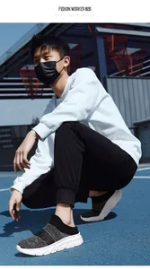 Close-up of lightweight black knit sneakers and joggers on a navy athletic court