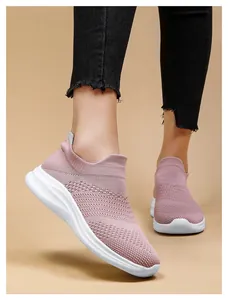 Detail of pink knitted slip-on sneakers with breathable fabric and cushioned white sole
