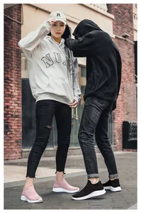 Outdoor street view of breathable knitted couple sneakers in pink and black colors