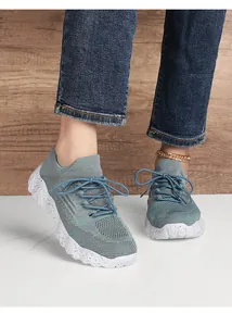 Detail of blue-grey knitted walking shoes with breathable mesh and wavy thick soles