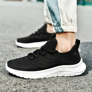 Men's breathable black knit running shoes with thick white soles on asphalt road