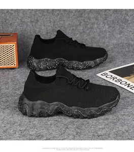 Detail shot of breathable black knit mesh sneakers with stylish white speckled thick soles