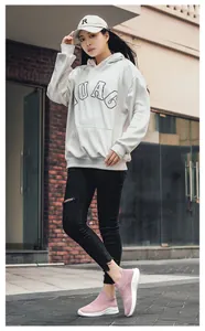Outdoor street view of pink breathable mesh walking shoes on model in stylish outfit