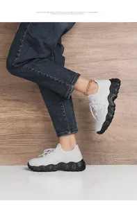 Detail of white breathable mesh sneaker with thick black speckled platform rubber sole