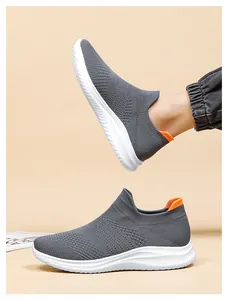 Detail of grey flyknit walking shoes with white wavy soles and orange heel tabs