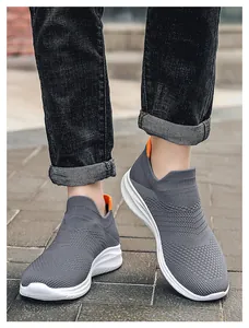 Detail of grey knitted walking shoe with breathable mesh and orange heel pull tab