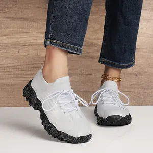Women's white flyknit sneakers with unique black polka dot platform soles for casual comfort