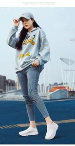 Outdoor lifestyle view of grey hoodie, blue jeans, and white breathable slip-on sneakers