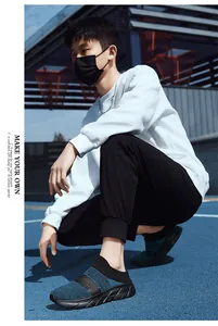 Side view of men's breathable knit sock sneakers with thick black sole on an athletic court