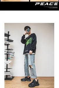 Nahaufnahme von schwarzen Streetwear-Sneakern mit hellblauer Distressed-Denim-Jeans