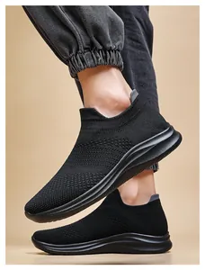 Close-up of black breathable knit sneakers with elastic sock-style collar on feet