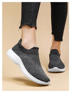 Close-up of grey knit sock sneakers with thick white wave patterned soles for casual wear