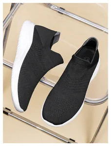 Detailed macro view of black knitted slip-on sneakers with size 41 marking and white sole
