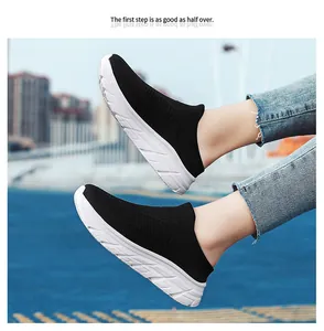 Detail shot of black knit slip-on sneakers with thick white textured rubber soles
