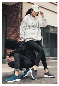 On-street view of casual knitted walking shoes in blue and dark grey with thick white soles