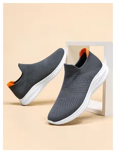 Detail of dark grey fly-knit mesh fabric and orange heel tab on sports sneakers