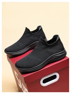 Detail view of black breathable knit walking sneakers showing flexible mesh and heel pull tab