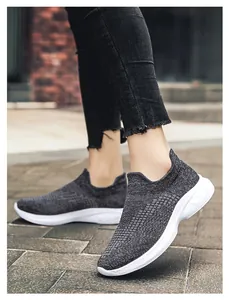 Close-up of breathable grey knitted slip-on walking shoes with white cushioned sole