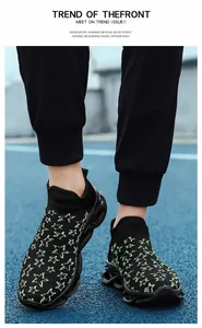 Dettaglio di sneaker a calzino in maglia con motivi a stella verde neon su mesh nero