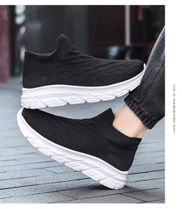 Detail of black fly-knit upper texture and cushioned white sole on men's walking shoes