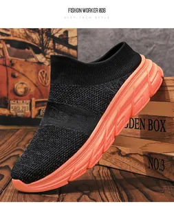 Detail of knit sock sneakers with thick orange rubber soles and slip-on city-tech style