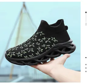 Dettaglio laterale di sneaker in maglia nera con stelle verdi e suola a onde cave