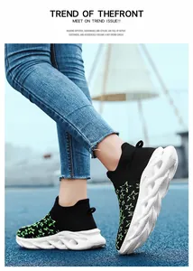 Dettaglio di sneaker in maglia nera con stelle verdi su sfondo blu del parco